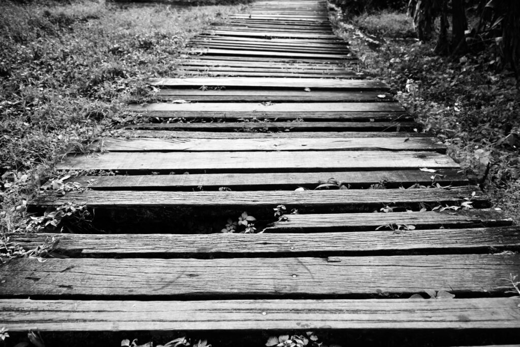old and dirty broken wood bridge on walk way in black and white photography