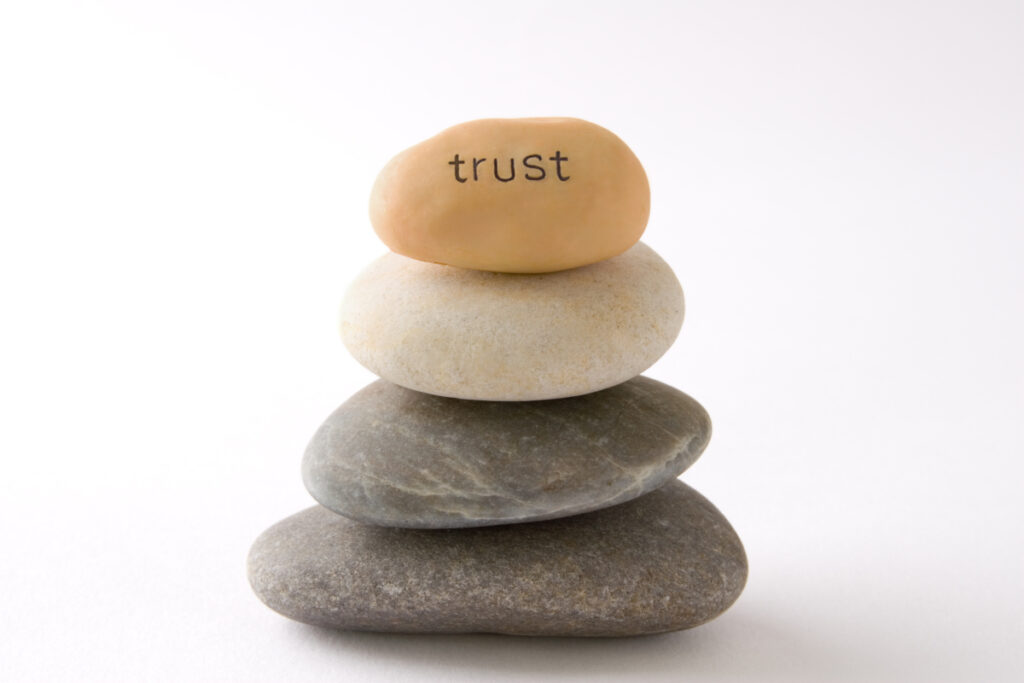 A small stack of pebbles, with 'Trust' written on the top stone